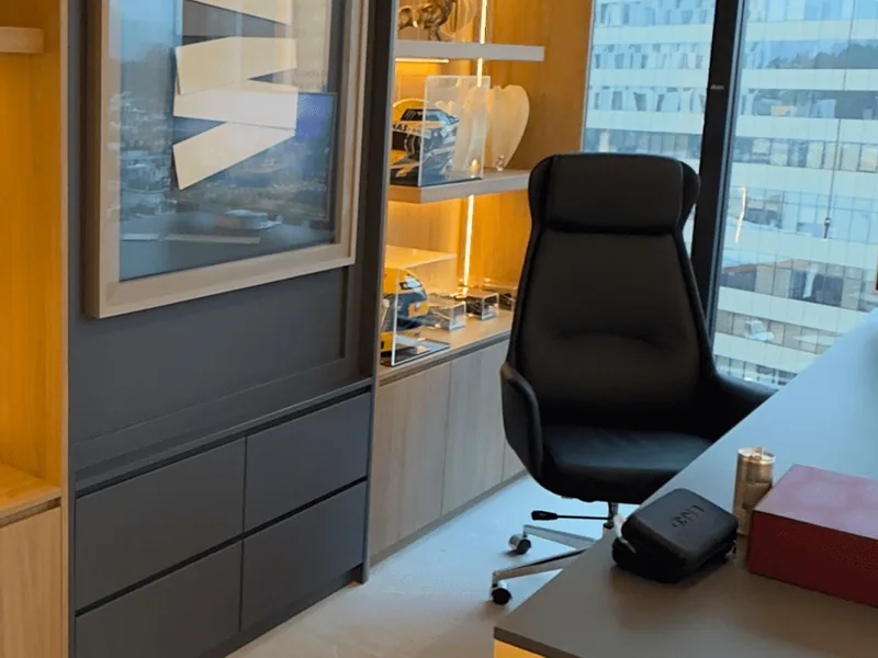 Sala do Instituto Evollution com mesa de trabalho, poltrona e prateleiras iluminadas, com vista para Alphaville